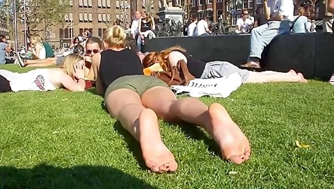 Cute Blonde Sunbathing Her Naked Soles And Feet On The Local Square