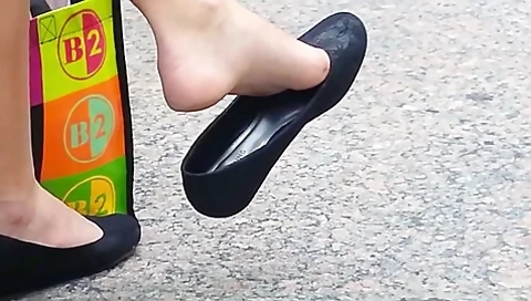 Girl Relaxes, Twirling Around Her Shoe While Her Feet Are Filmed By
