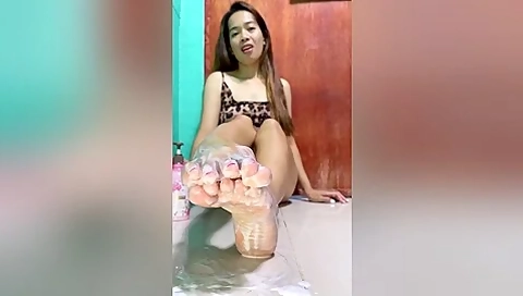 Cute Filipina Applying Body Lotion On Her Sexy Feet And Toes With Red