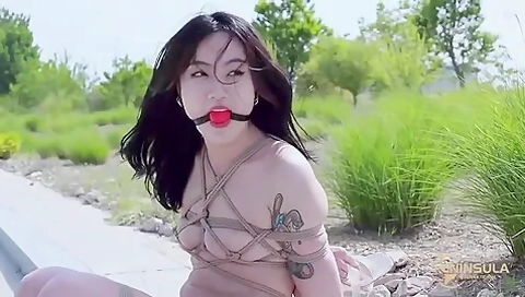 Bound Asian Girl Hops Outdoors